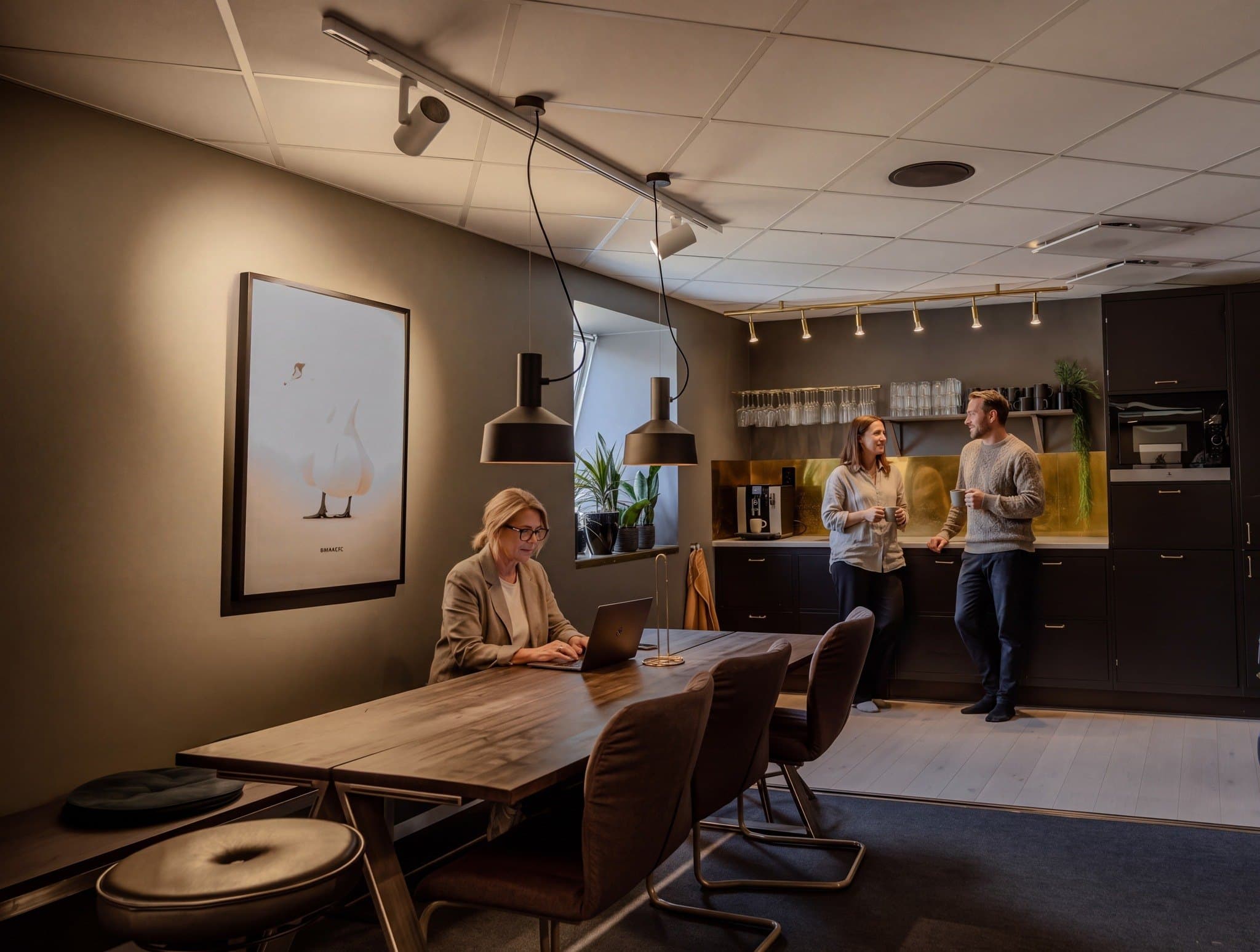 Kök och matplats på River Street Lab i Linköping där två kollegor fikar vid kaffemaskinen och en tredje jobbar vid matbordet